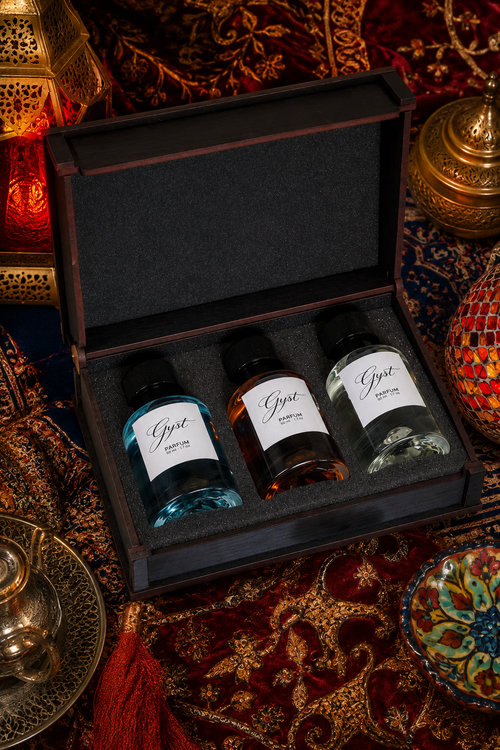 GYST perfume gift box open on a Persian rug with brass lanterns