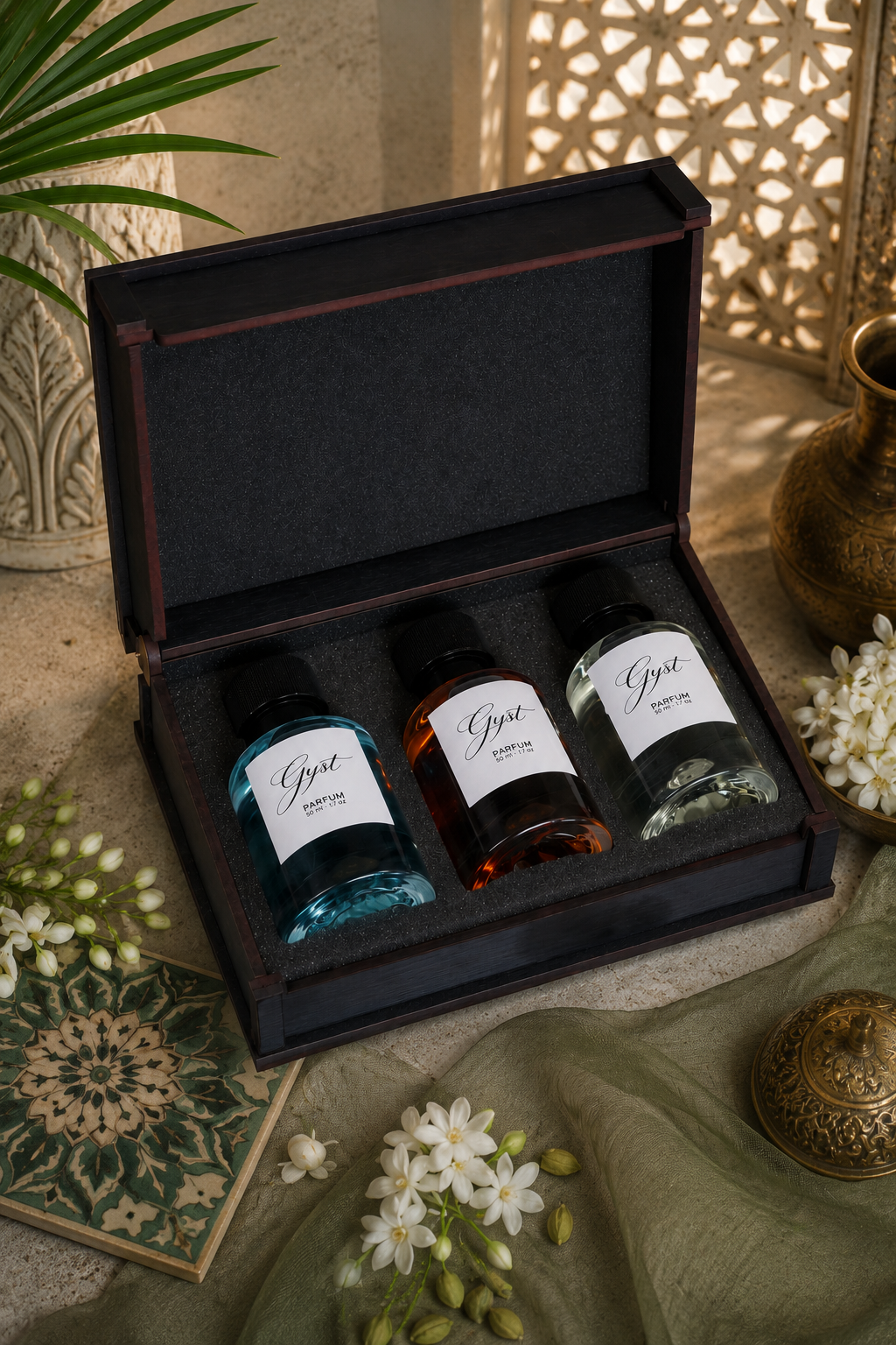 GYST perfume gift box with three 30ml perfumes beside jasmine flowers